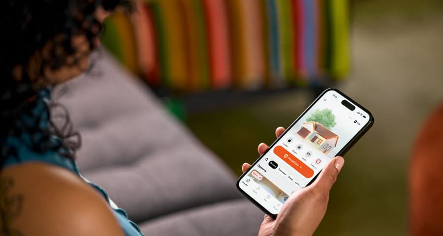 Person utilizing the HomeView tool in the Vivint app to find insights into security, automation, and energy usage.